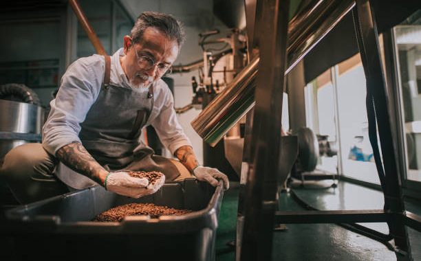 Ilustrasi seorang pria sedang memeriksa proses penghilangan batu biji kopi di pabriknya. Sumber: istockphoto.com